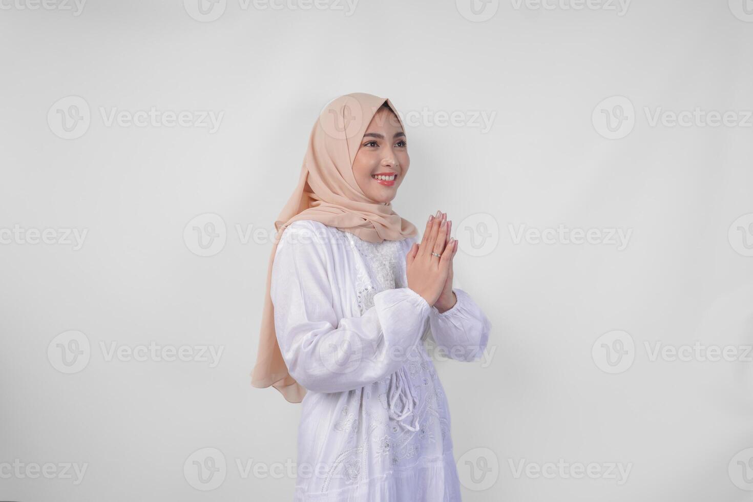 magnifique asiatique musulman femme portant blanc robe et hijab souriant tandis que Faire formel Bienvenue ou salutation geste, permanent plus de isolé blanc Contexte photo