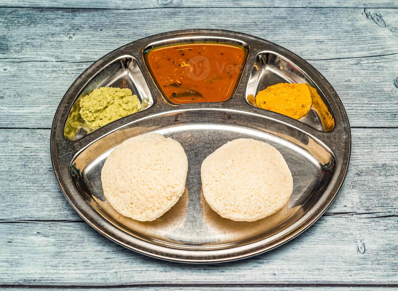 podi idli thali avec curry servi dans plat isolé sur en bois table Haut vue de Indien épicé nourriture photo