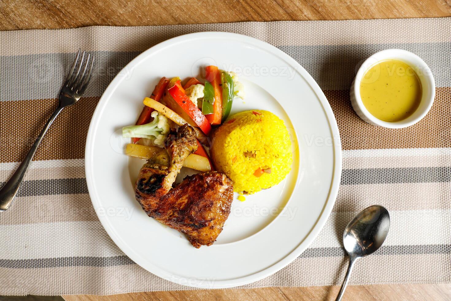 rôti poulet avec herbe riz avec salade, plonger, cuillère et fourchette servi sur assiette isolé sur serviette de table Haut vue de vite nourriture sur table photo