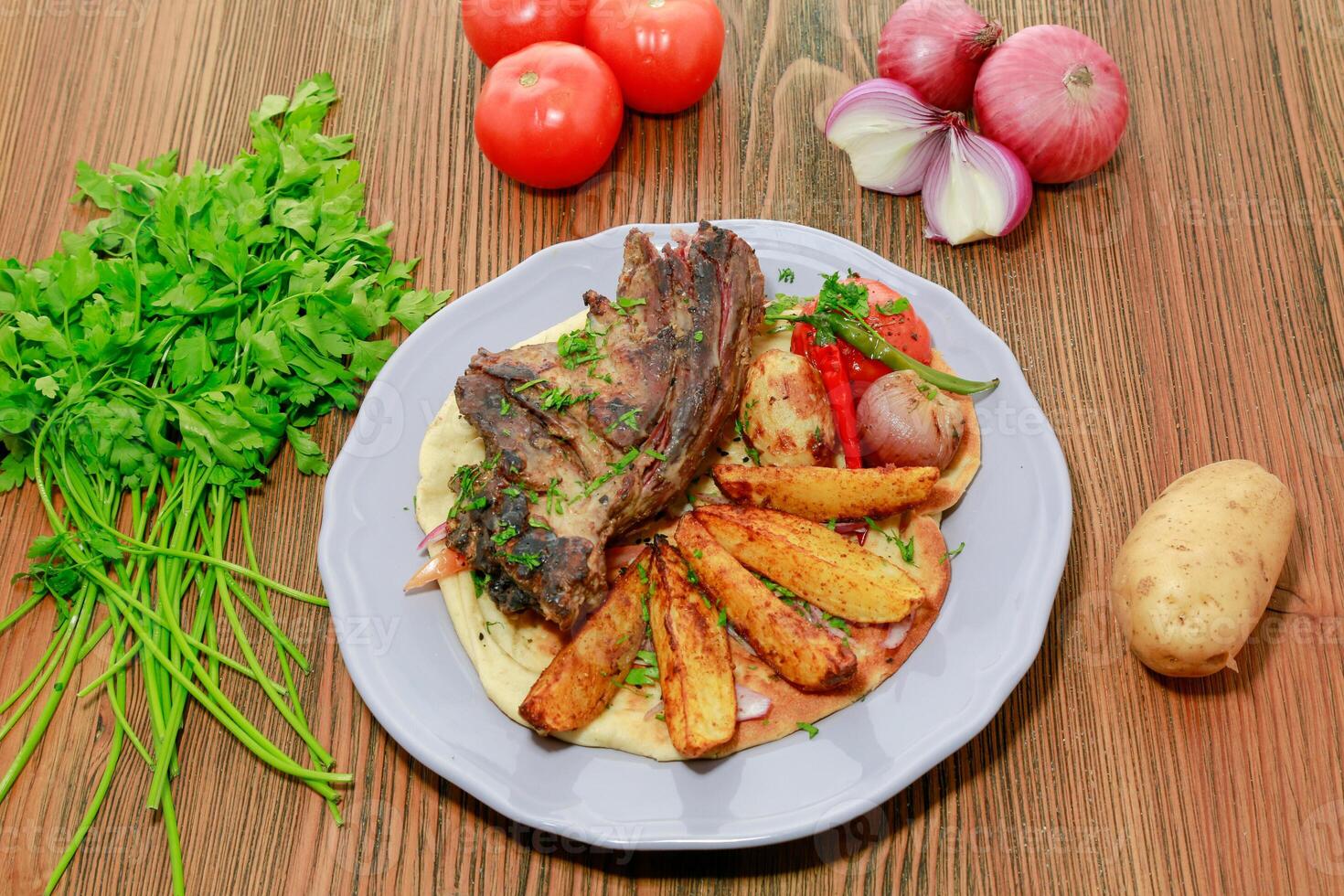 du boeuf rôti nifa nourriture avec Patate légumes, tomate, oignon et coriandre servi dans plat isolé sur table Haut vue de arabe nourriture photo