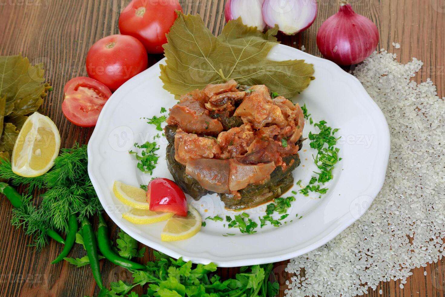 vigne feuilles casserole avec tomate, oignon, riz, coriandre, citron tranche et vert Chili servi dans plat isolé sur en bois table côté vue de arabe nourriture photo