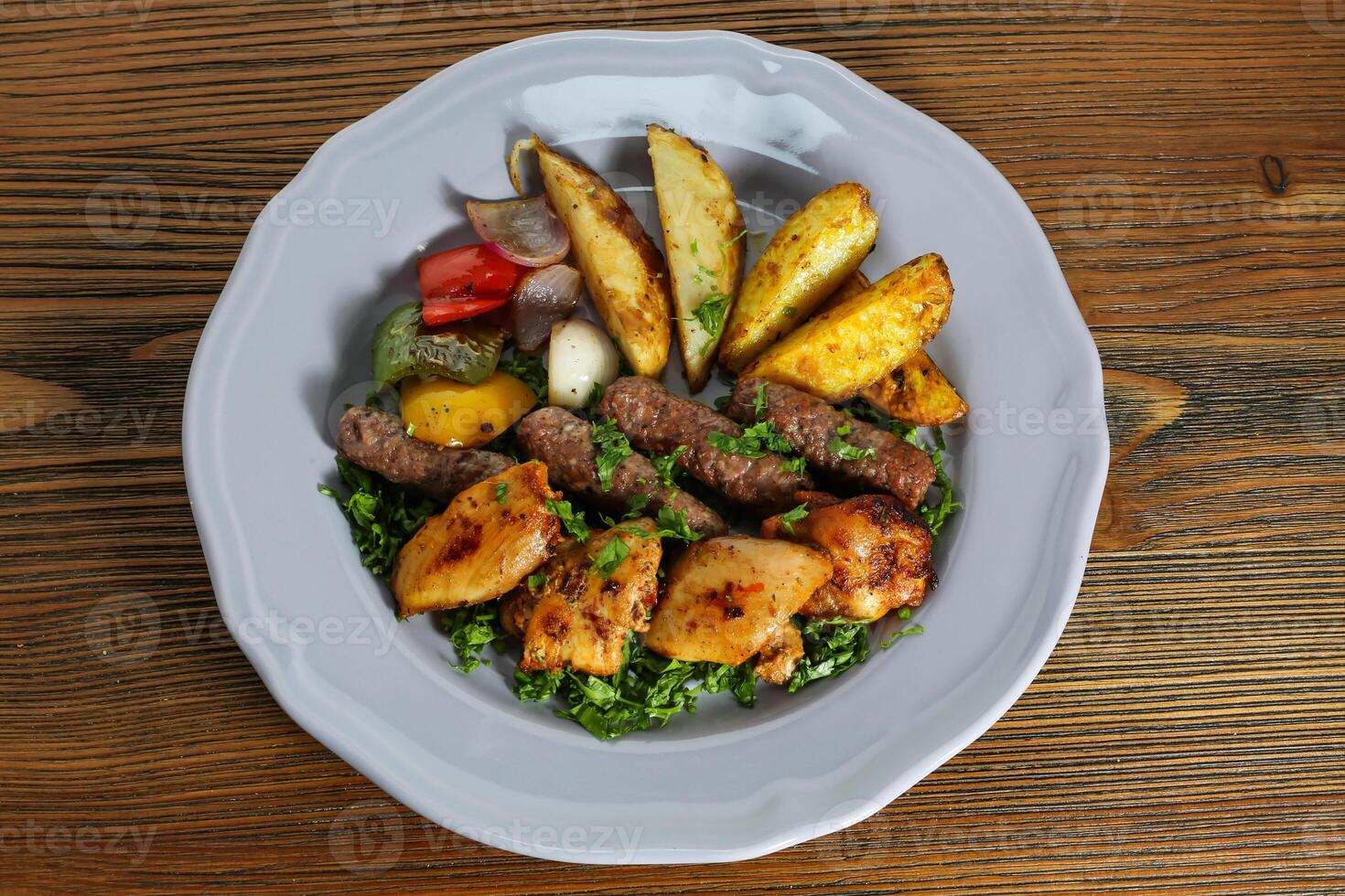 mélanger kofta et shish tawak kabab avec Patate légumes, tomate, oignon et coriandre servi dans plat isolé sur table Haut vue de arabe nourriture photo