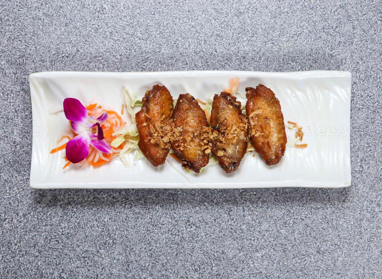Profond frit poulet ailes avec Citronnelle servi dans plat isolé sur gris Contexte Haut vue de Hong kong nourriture photo