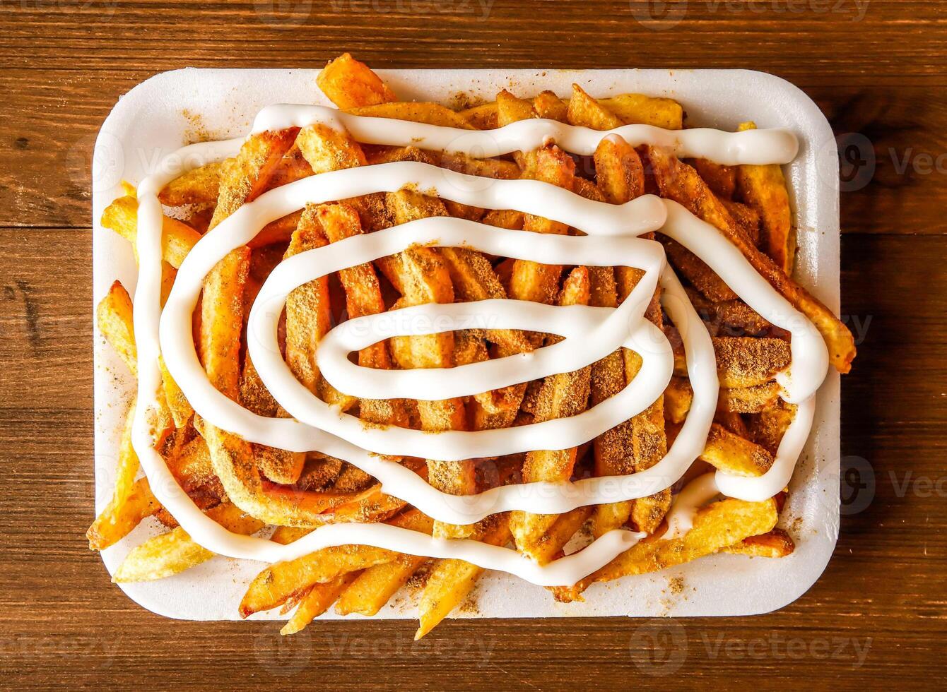 mayo frites avec Masala ou Patate frites chargé avec Mayonnaise servi dans plat isolé sur en bois Contexte Haut vue de Indien épices et pakistanais nourriture photo