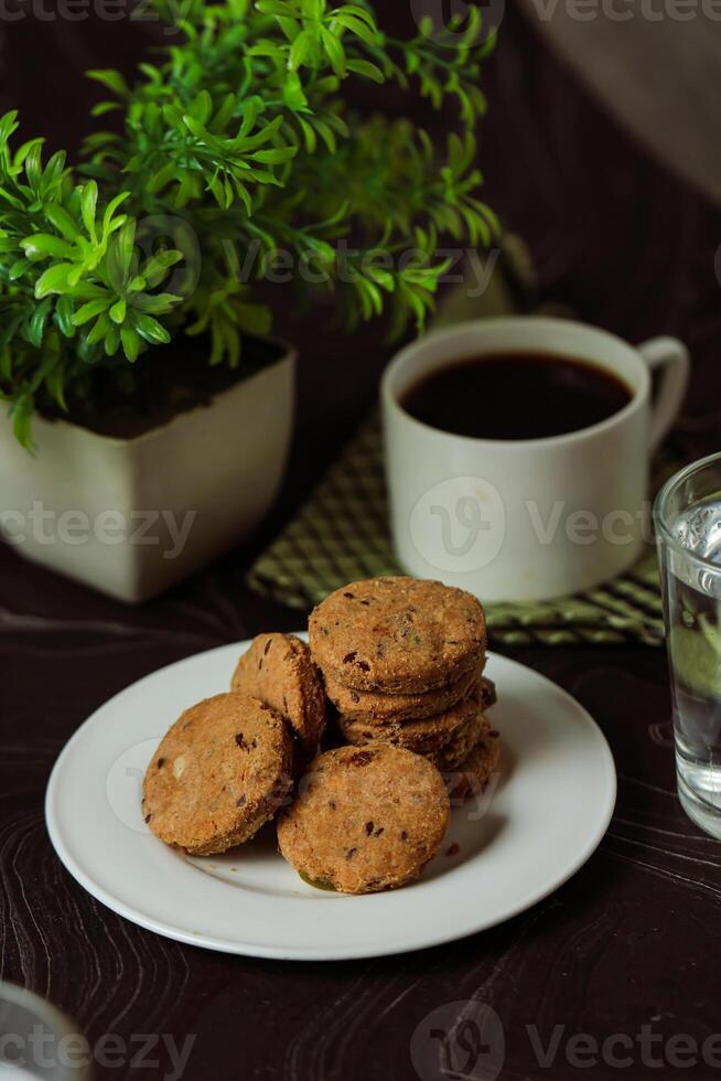 croquant biscuits des biscuits servi dans assiette avec noir café et verre de l'eau isolé sur table côté vue de américain café cuit nourriture photo