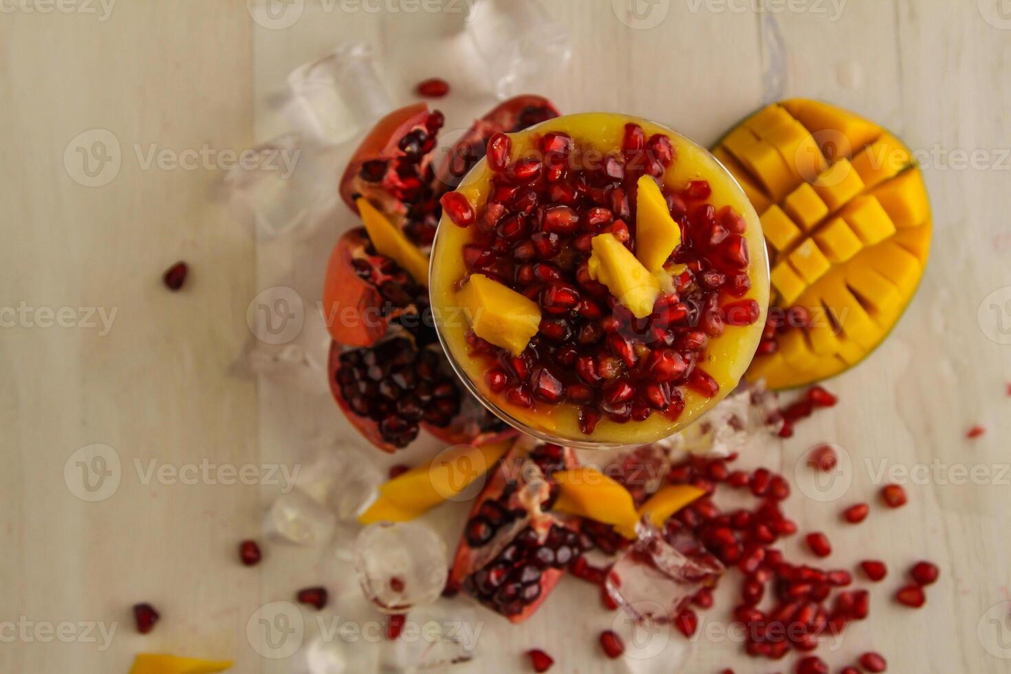 mangue jus et Grenade des graines servi dans jetable verre isolé sur table Haut vue de en bonne santé boisson photo