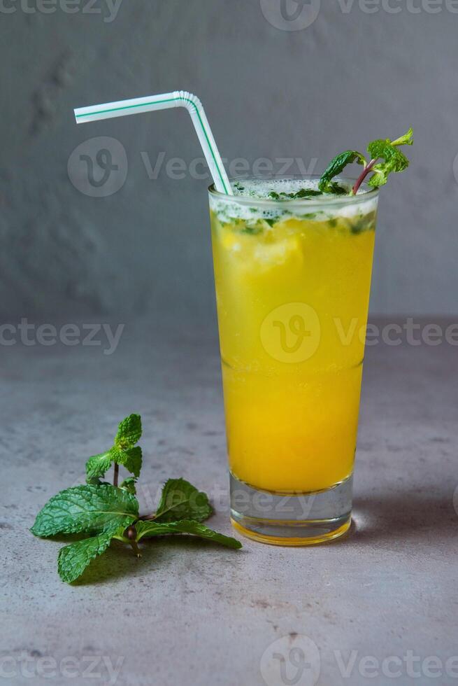 en bonne santé passion fruit Mojito Frais jus servi dans verre avec menthe paille côté vue sur gris Contexte photo