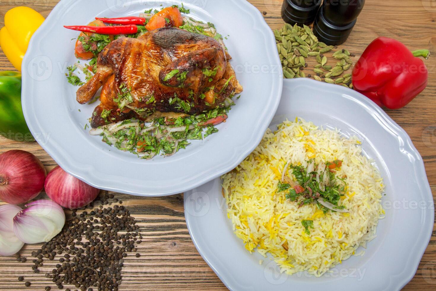 moitié grillé poulet avec Pulao riz biryani, noir poivre, cloche poivrons, tomate et oignon servi dans plat isolé sur table Haut vue de arabe nourriture photo