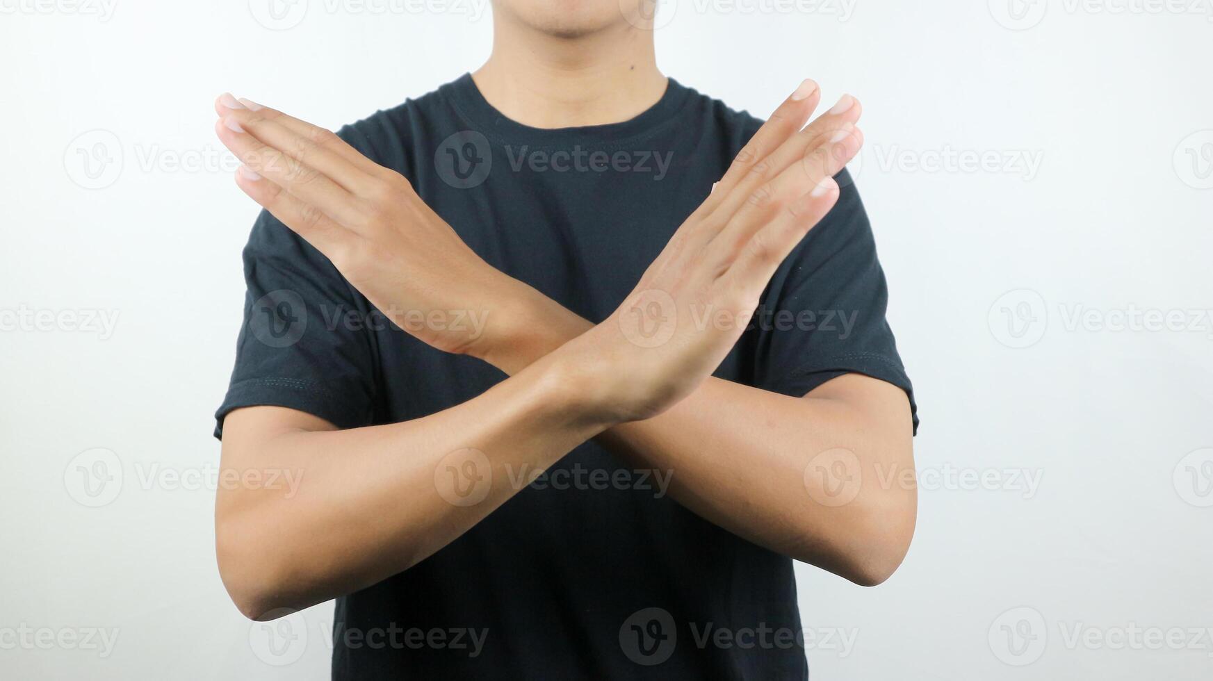 Oh non geste de une homme dans noir chemise traversée le sien bras, refusant quelque chose. photo