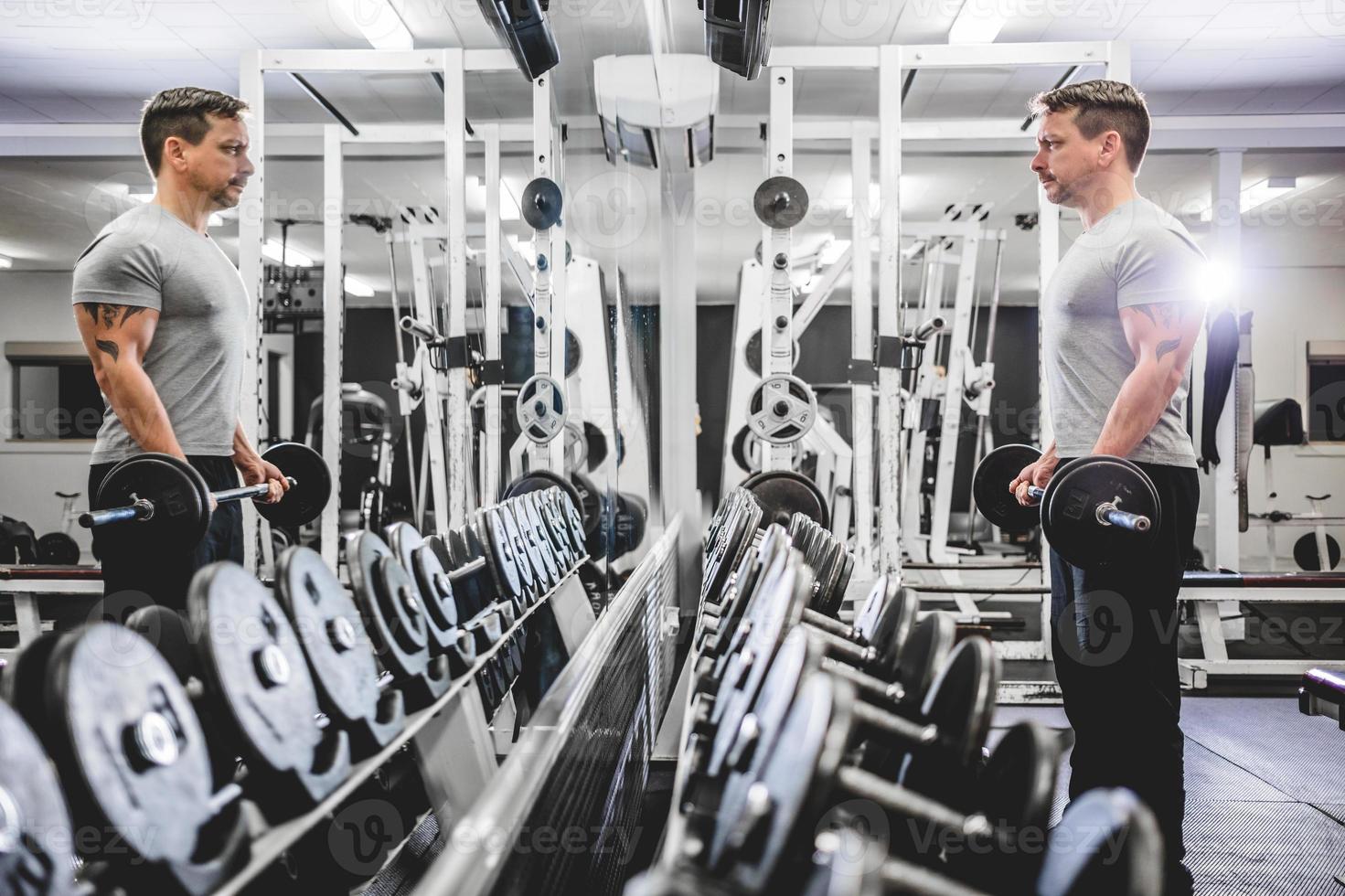 bodybuilder soulevant des haltères dans une salle de sport. photo