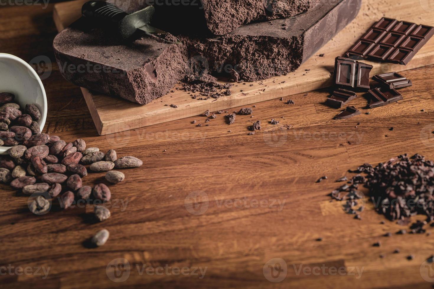 arrangement de vue de dessus de table sucrée de fèves de cacao, de nibs et de barres de chocolat photo