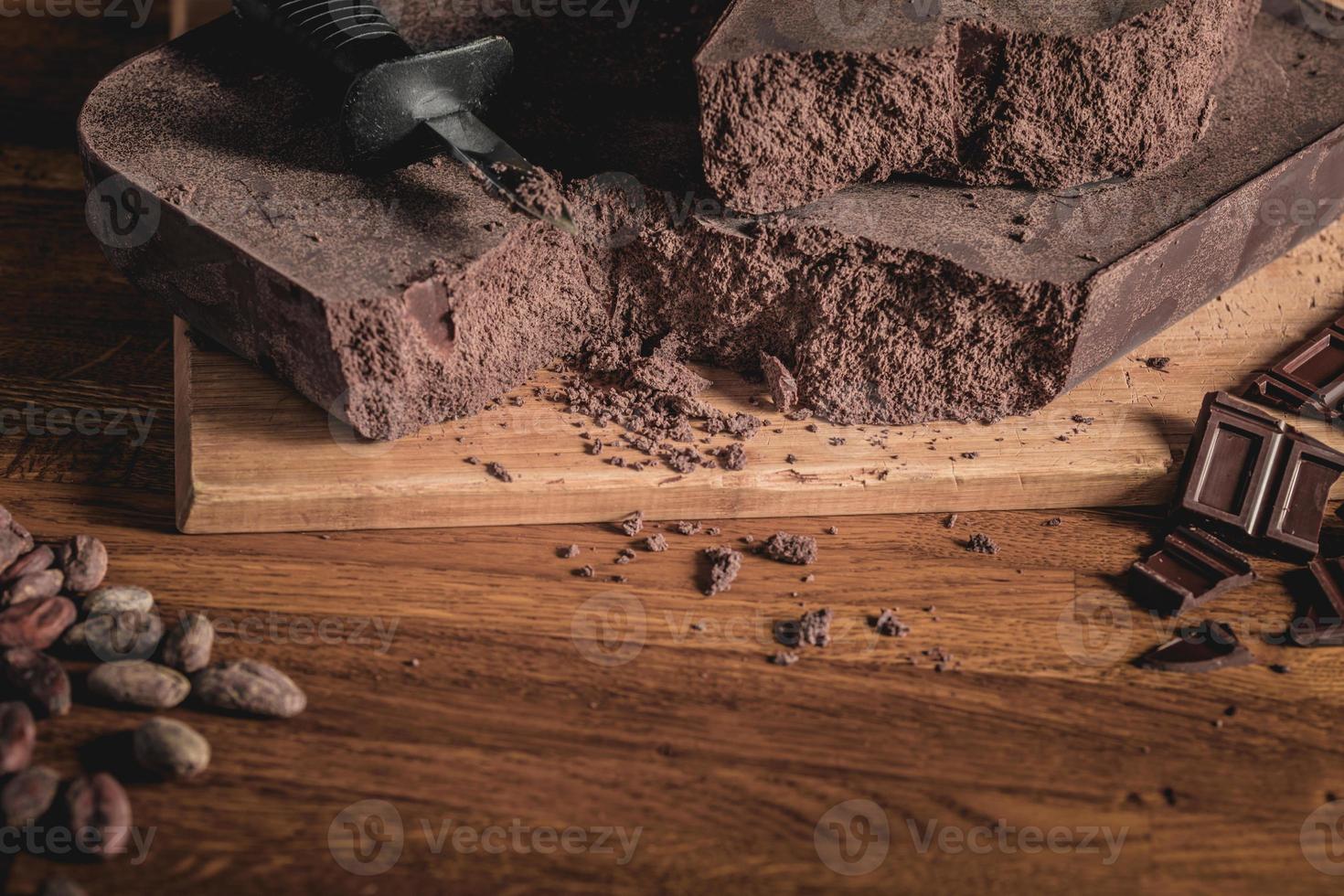 arrangement de fèves de cacao, de nibs et de barres de chocolat sur une surface en bois. photo