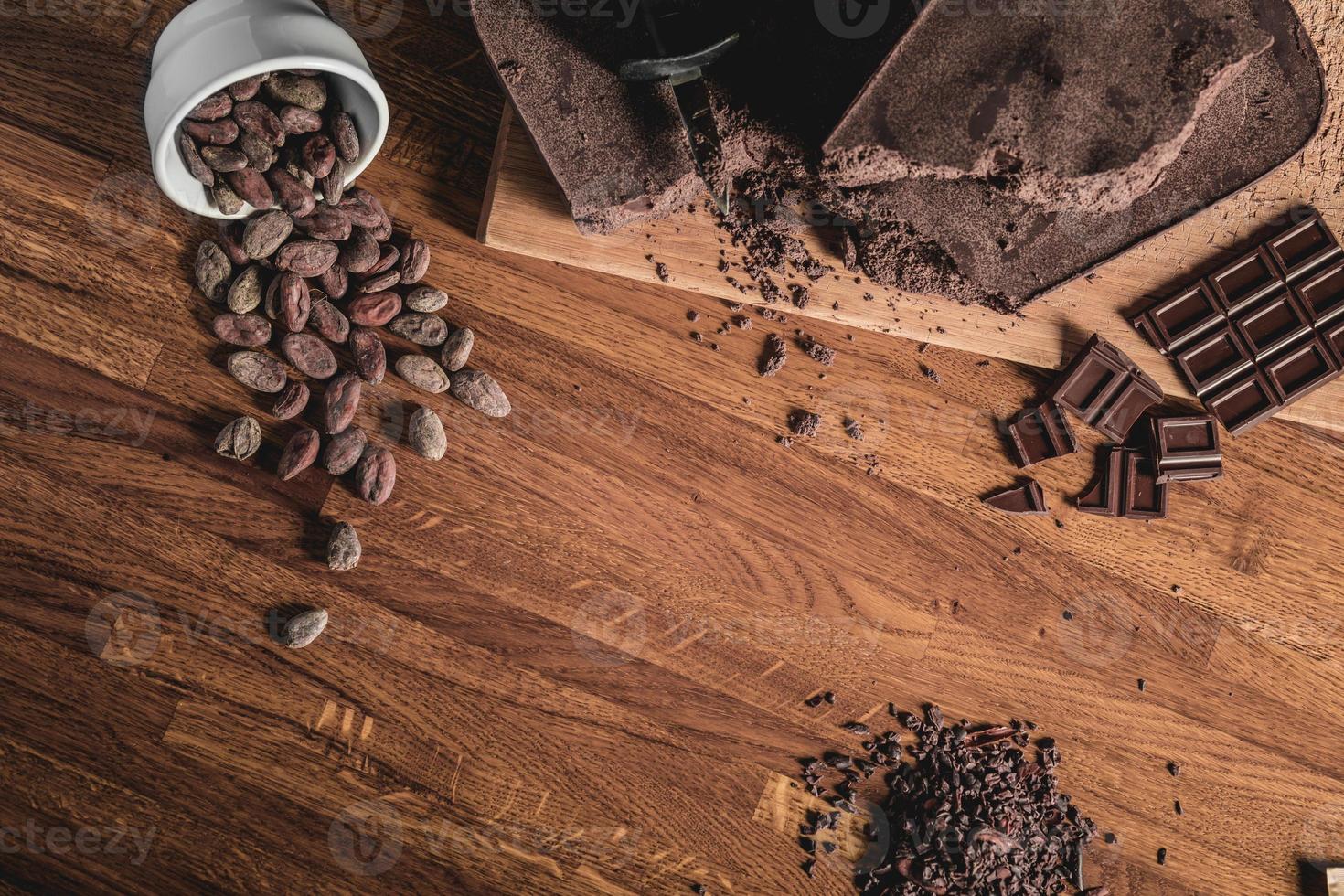 arrangement de vue de dessus de table sucrée de fèves de cacao, de nibs et de barres de chocolat photo