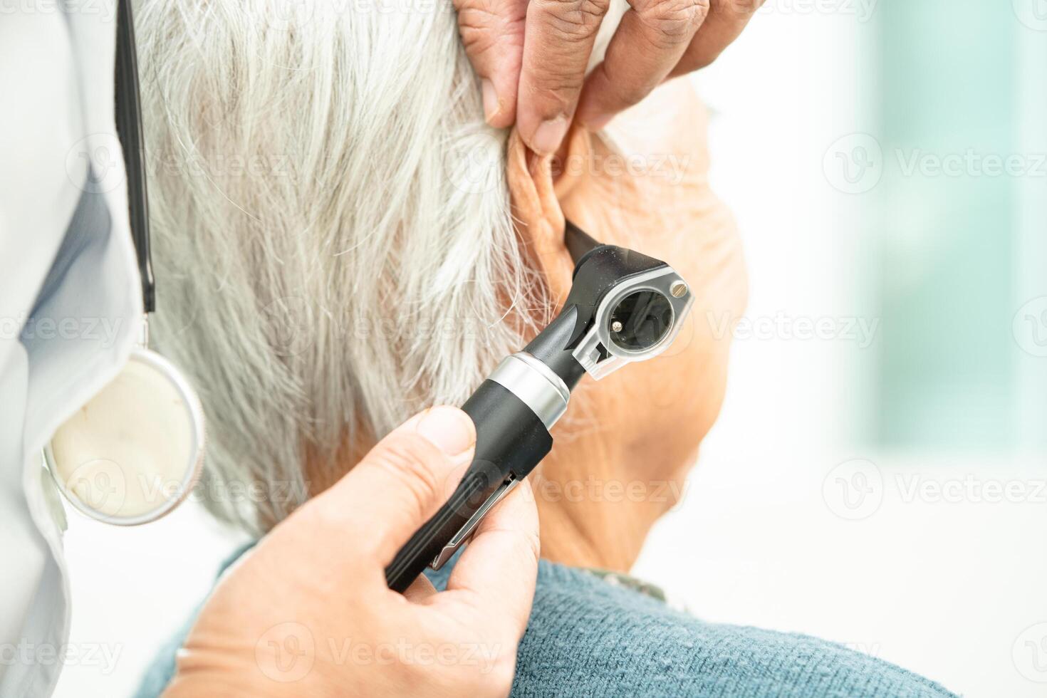 audiologiste ou ent médecin utilisation otoscope vérification oreille de asiatique Sénior femme patient traiter audition perte problème. photo