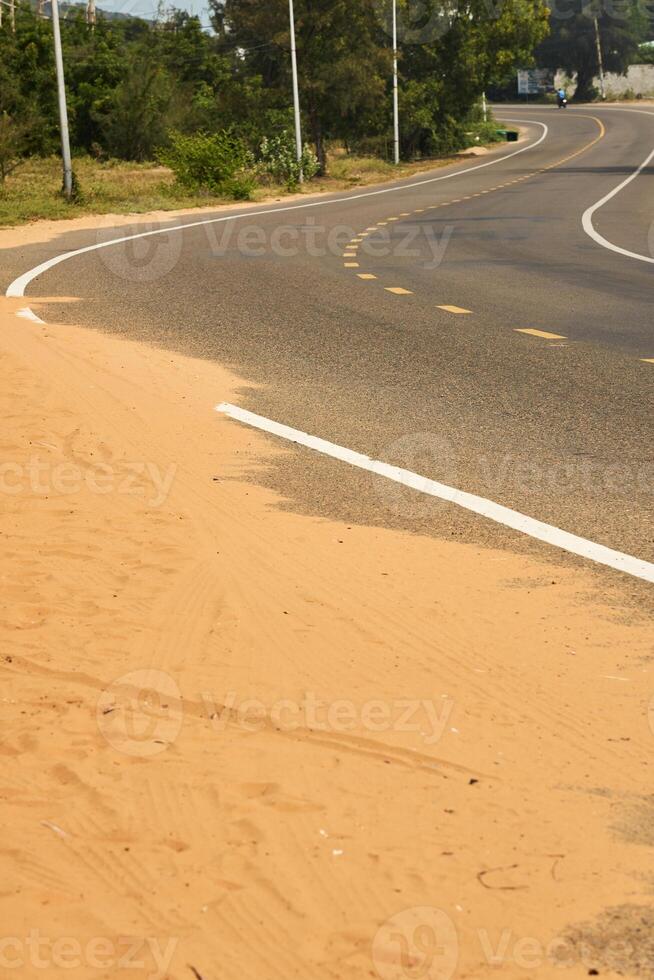 désert le sable pas sur un asphalte route. photo