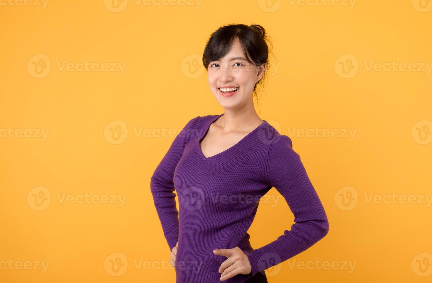 une de bonne humeur Jeune femme portant une violet chemise et lunettes, dans une studio portrait, affichage confiance et positivité contre une vibrant Jaune Contexte. photo