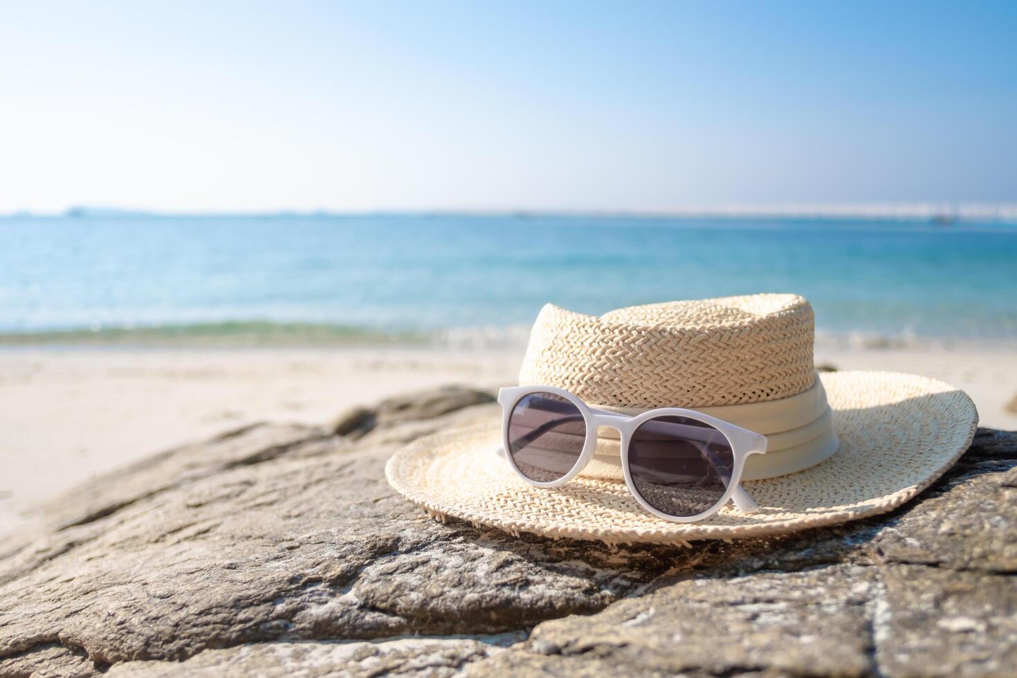 paille chapeau et des lunettes de soleil sur le plage. photo