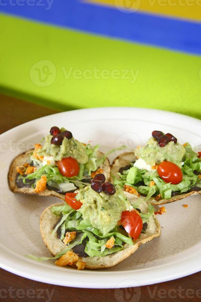 traditionnel tostada, classique de mexicain cuisine avec laitue, haché tomates, frit poulet frites photo