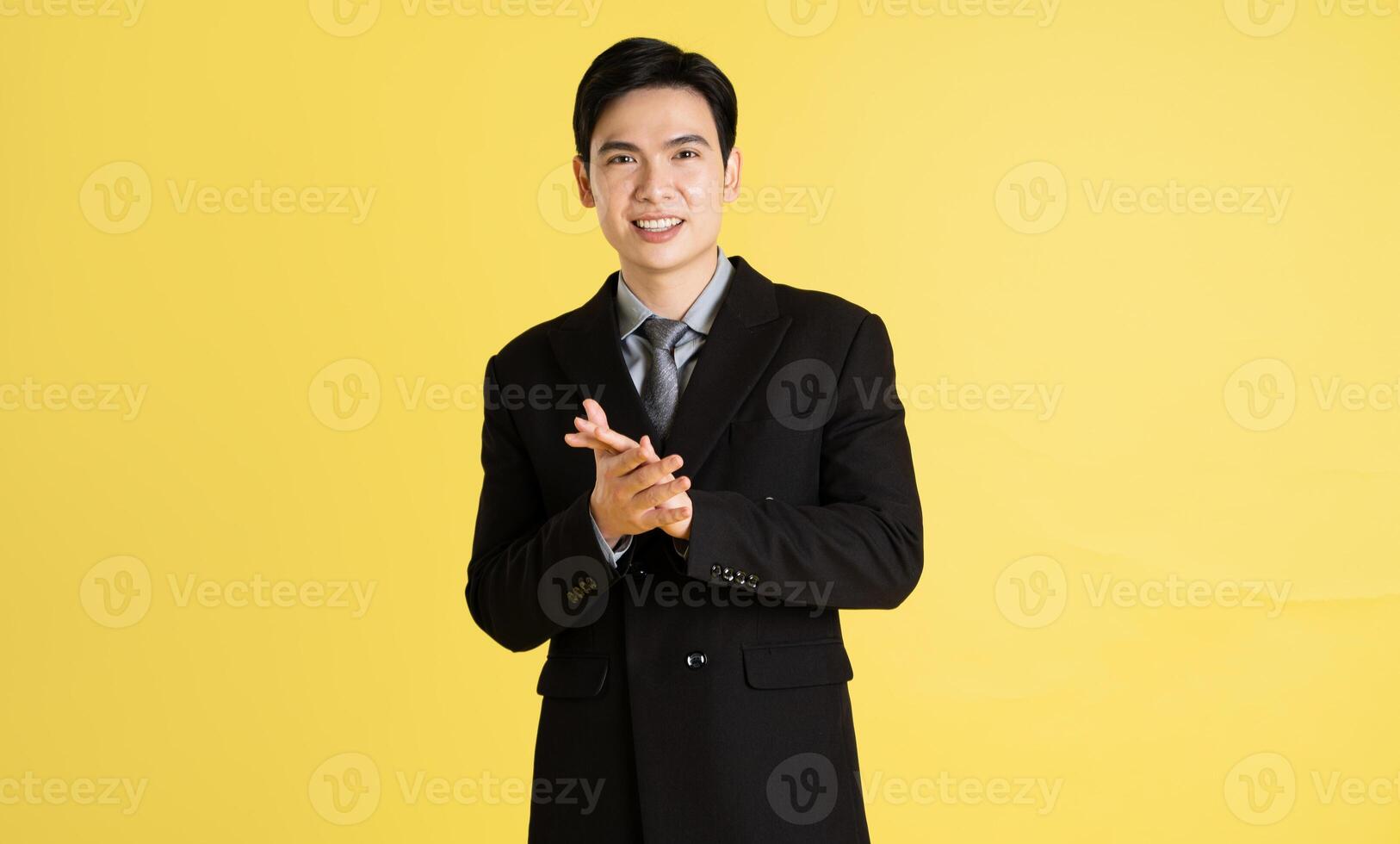 portrait de asiatique Masculin homme d'affaire. portant une costume et posant sur une Jaune Contexte photo