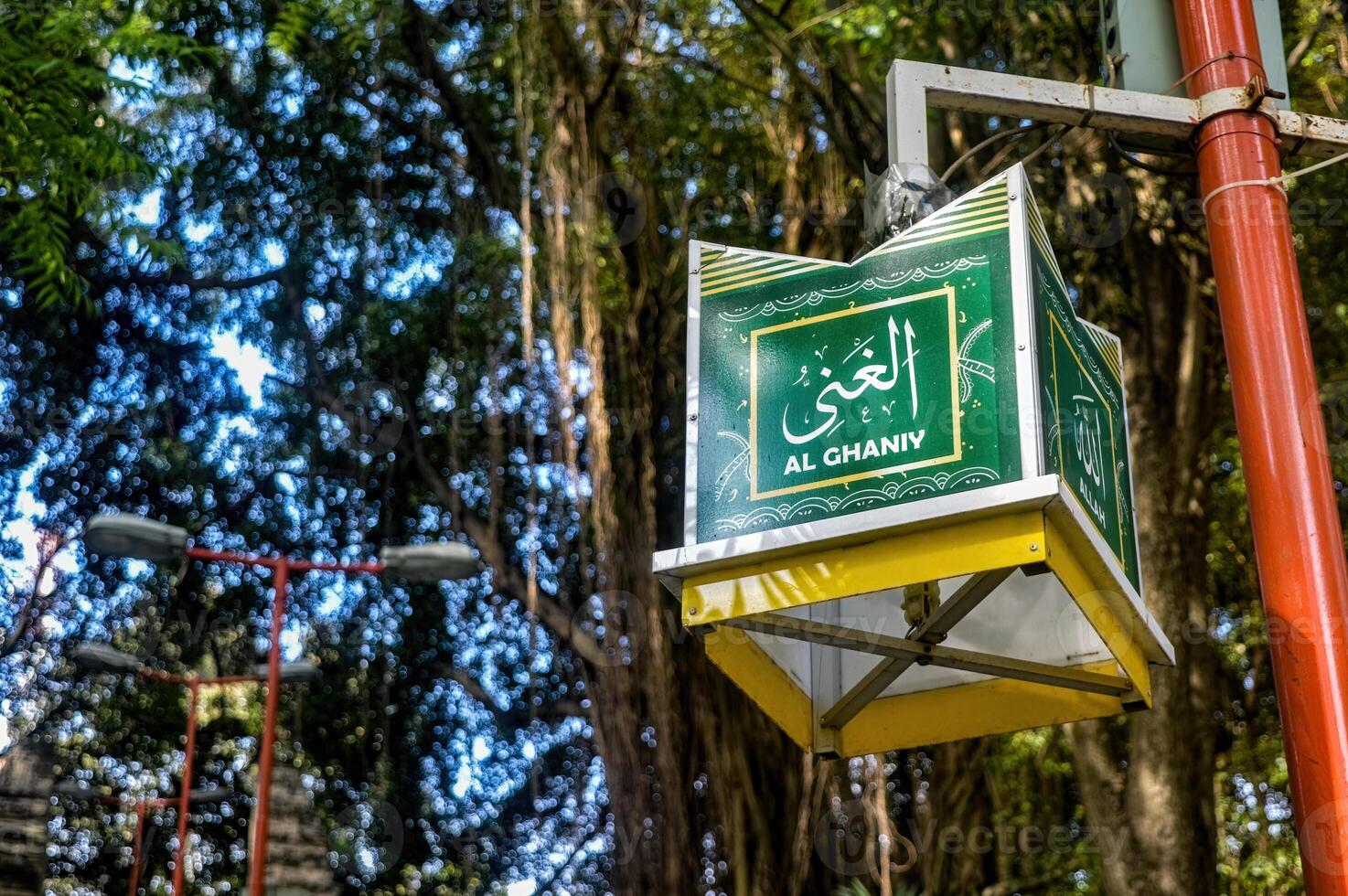 une rue lampe dans le forme de une damar kurung lanterne avec une Contexte de des arbres. Traduction sur lanterne le plus riches photo