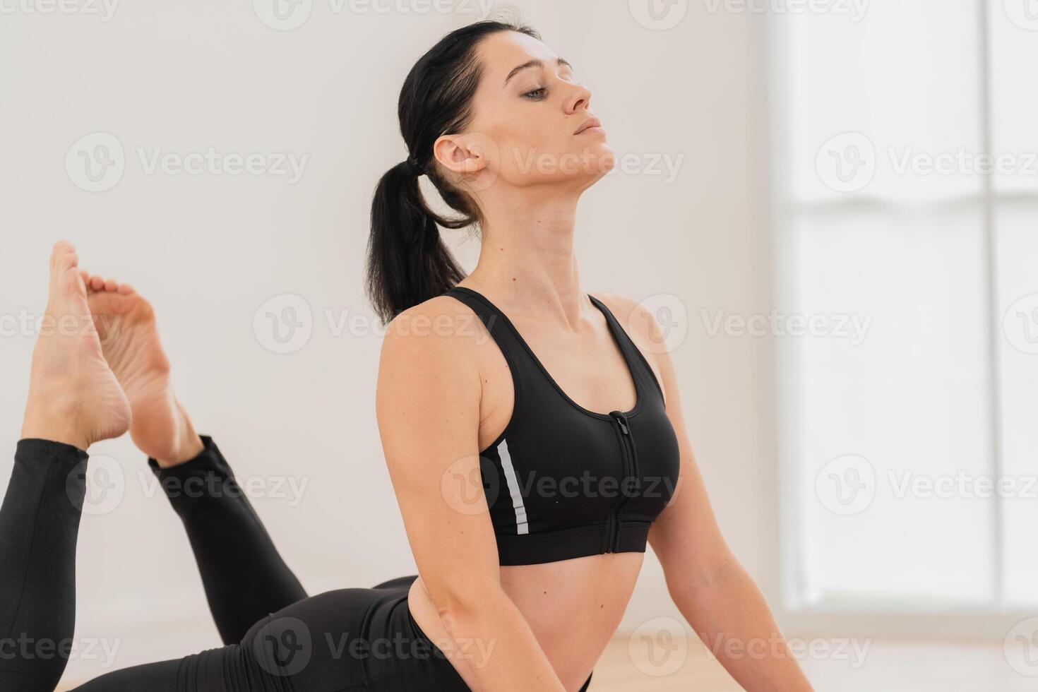 une Jeune femme avec une en bonne santé corps est pratiquant yoga dans une brillant yoga studio. yoga praticien. photo