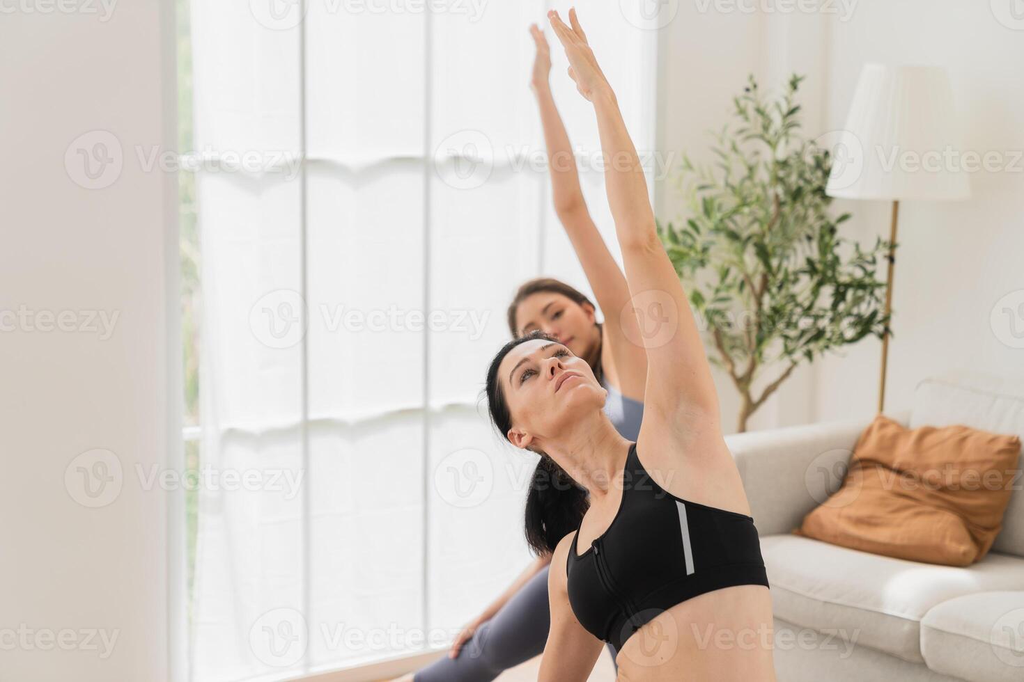 une Jeune en forme femme les pratiques yoga par Faire asanas dans une brillant yoga studio. yoga praticien avec élèves dans yoga classe. photo