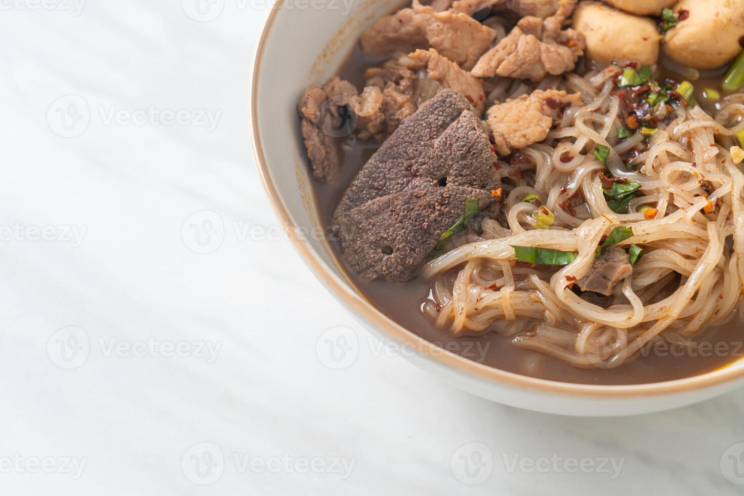 nouilles thaï au porc, ragoût de porc, boulette de viande et foie de porc dans une soupe de sang photo