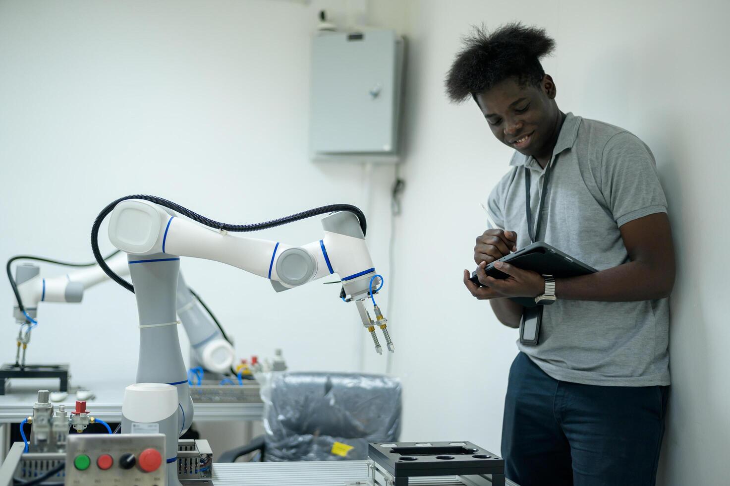 stagiaire la robotique ingénieur apprentissage avec programmation et manipuler robot main, industriel la robotique conception, haute technologie facilité, moderne machine apprentissage. Masse production automatiques. photo