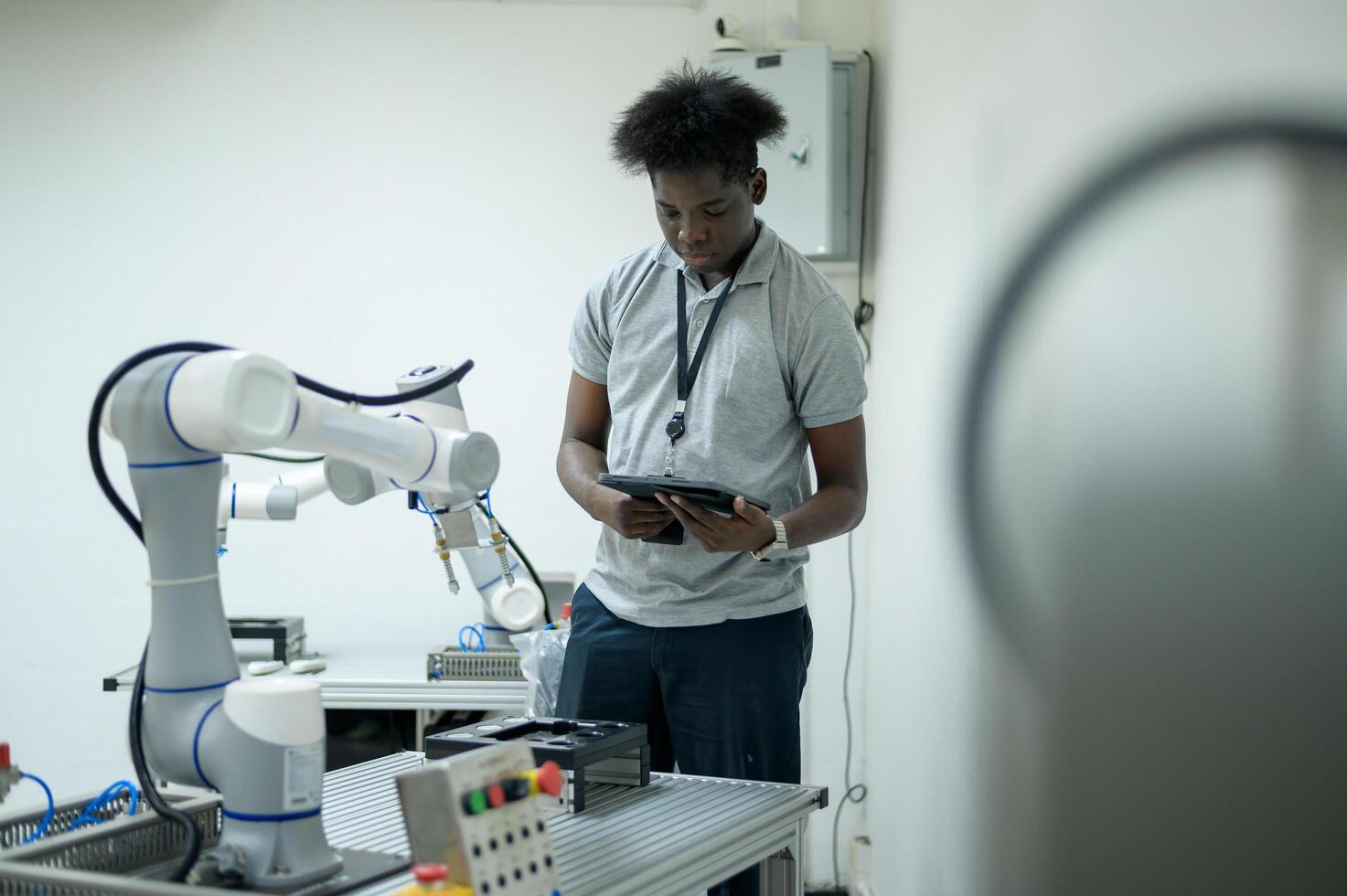 stagiaire la robotique ingénieur apprentissage avec programmation et manipuler robot main, industriel la robotique conception, haute technologie facilité, moderne machine apprentissage. Masse production automatiques. photo