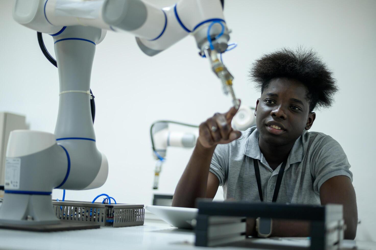 stagiaire la robotique ingénieur apprentissage avec programmation et manipuler robot main, industriel la robotique conception, haute technologie facilité, moderne machine apprentissage. Masse production automatiques. photo