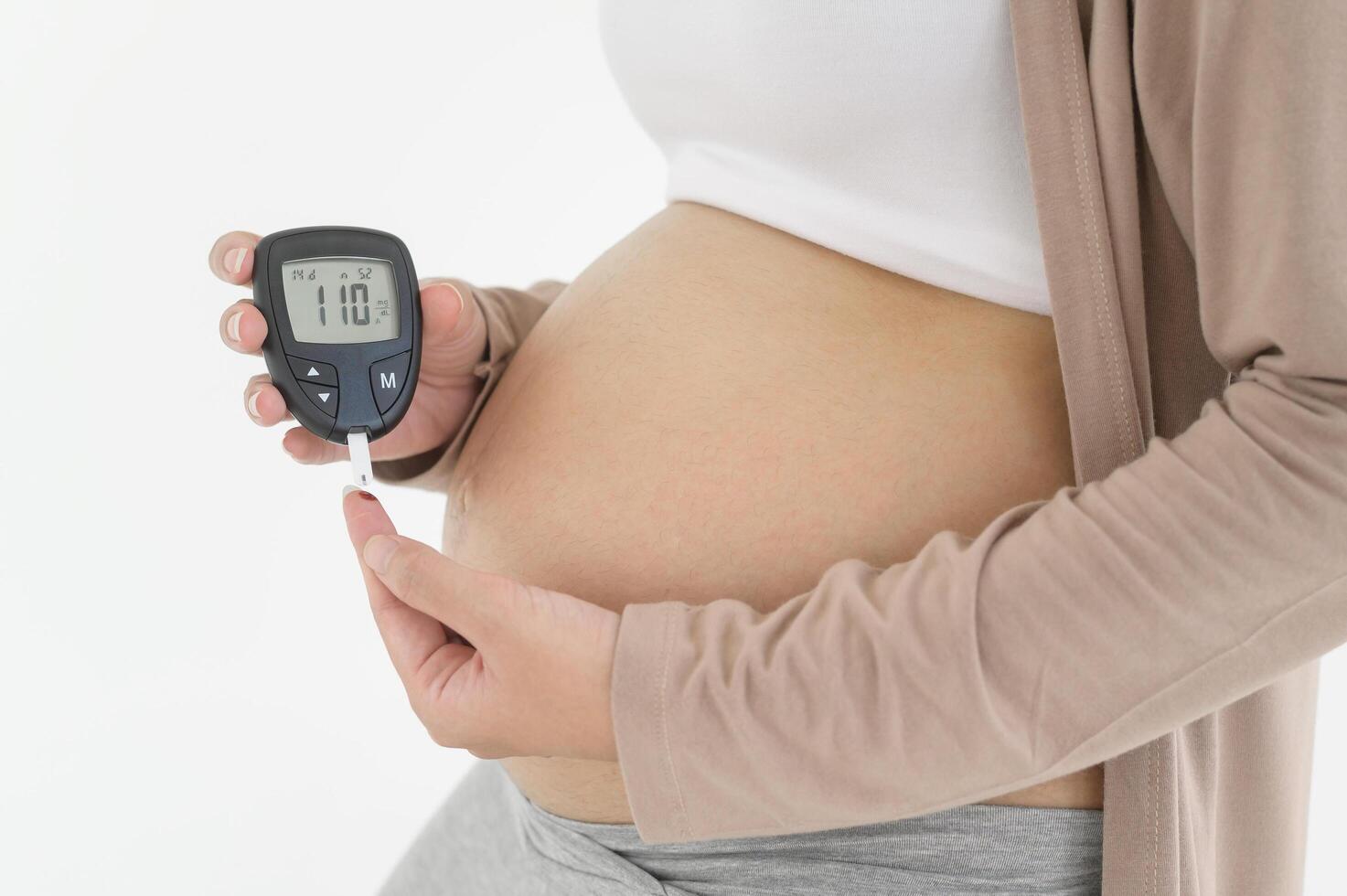 Enceinte femme vérification du sang sucre niveau par en utilisant numérique glucose mètre, santé se soucier, médecine, diabète, glycémie concept photo