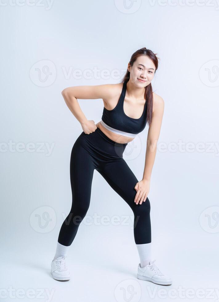 Jeune asiatique femme portant tenue de sport sur blanc Contexte photo