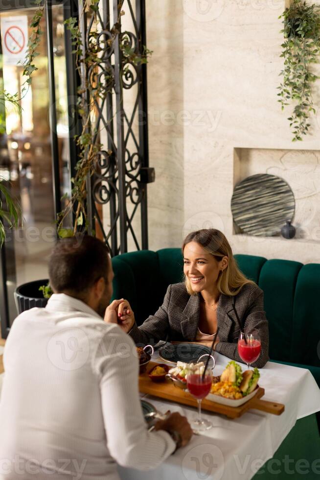 Jeune couple ayant le déjeuner et en buvant Frais pressé jus dans le restaurant photo