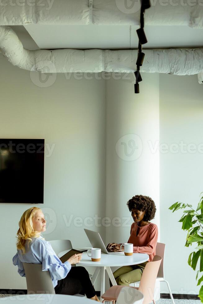 joyeux Bureau café Pause avec collègues partage une rire dans brillant espace de travail photo