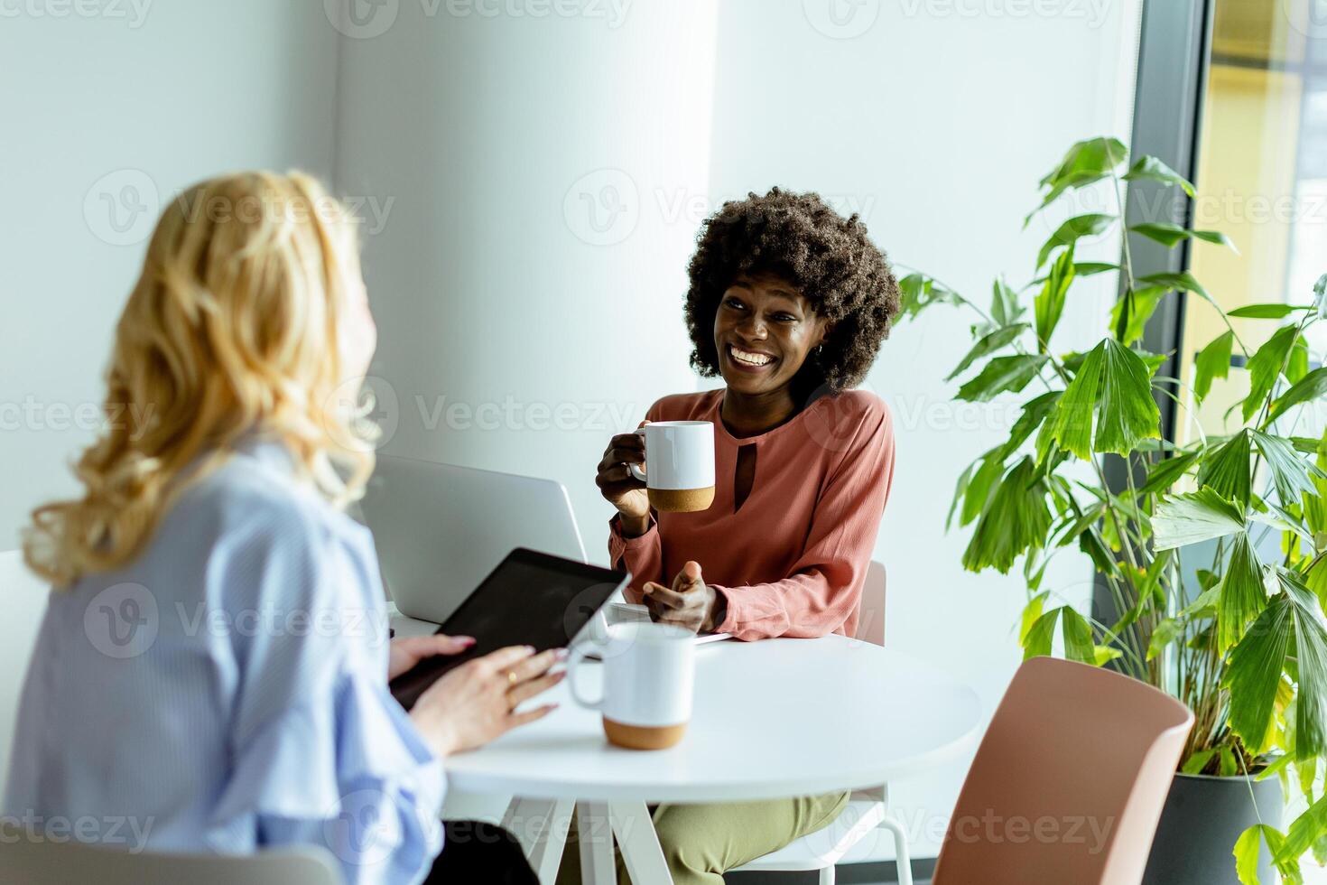 joyeux Bureau café Pause avec collègues partage une rire dans brillant espace de travail photo