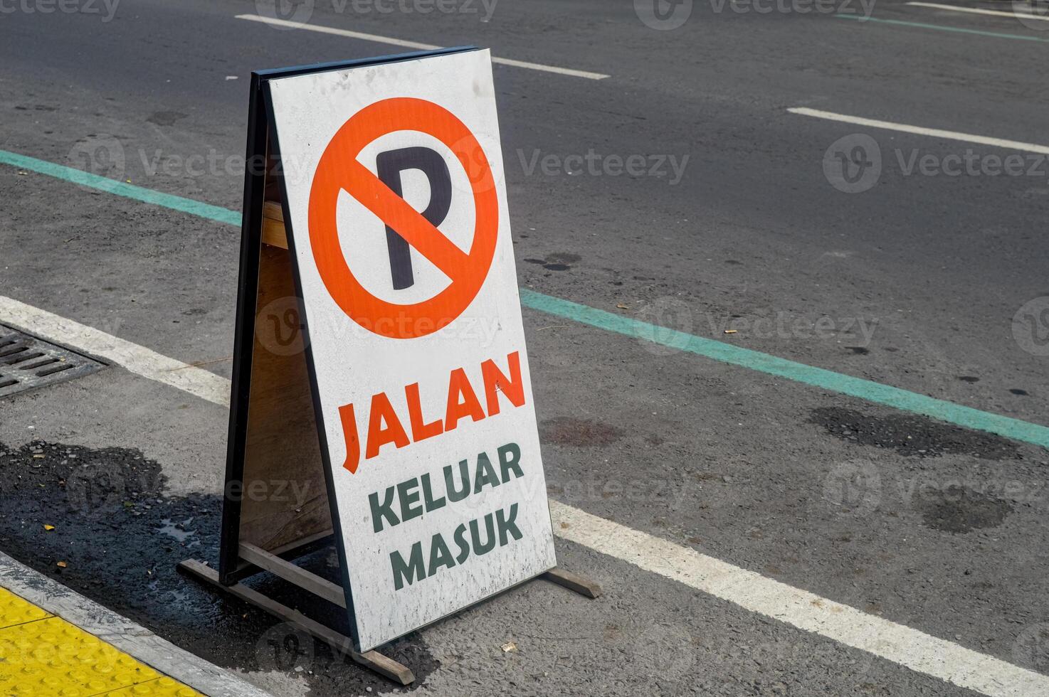 une planche contenant une signe cette non parking est permis sur le côté de le route. Traduction sur planche entrée et sortie. photo