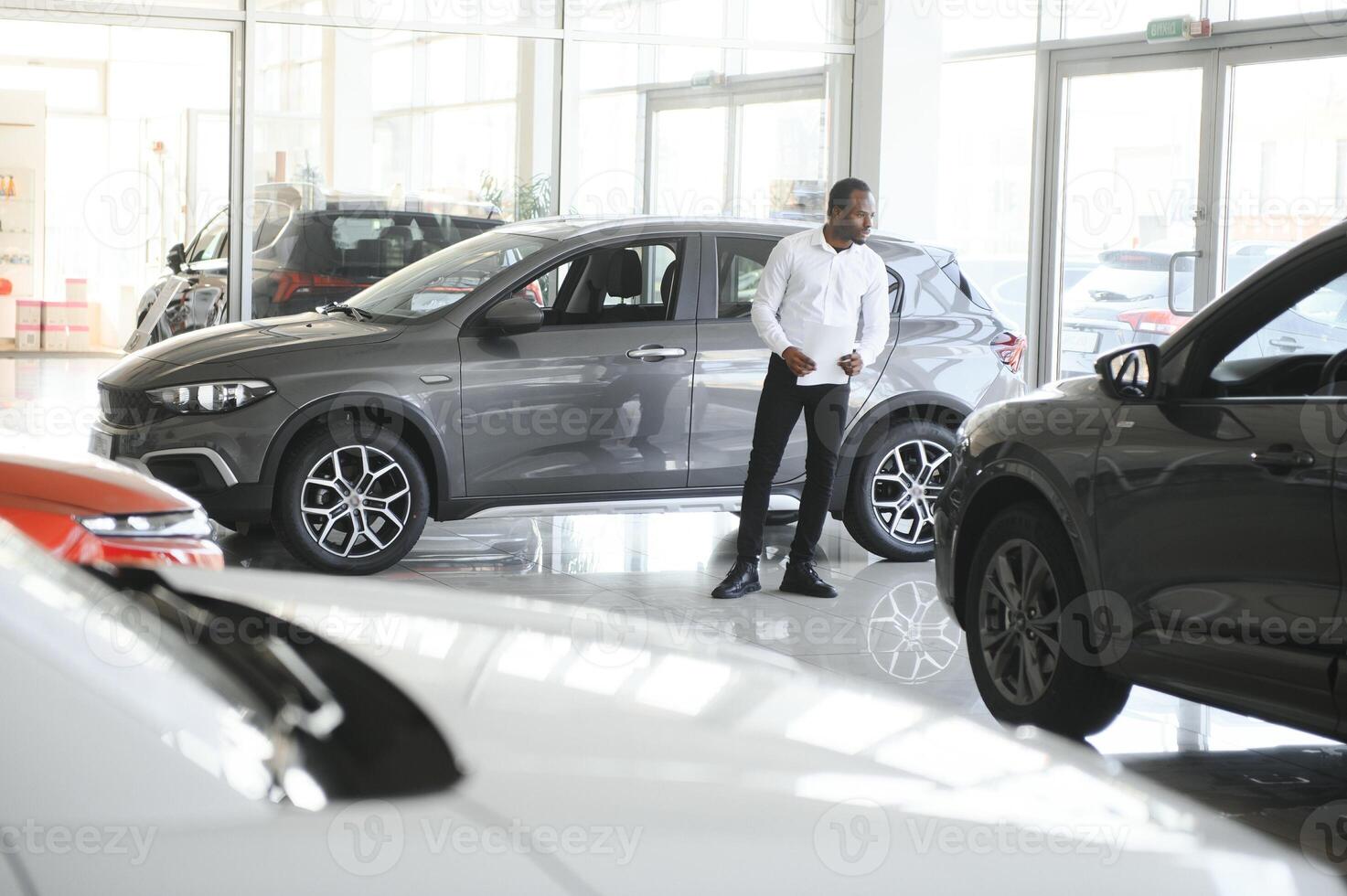 Jeune africain américain voiture concession principal permanent dans véhicule salle d'exposition photo