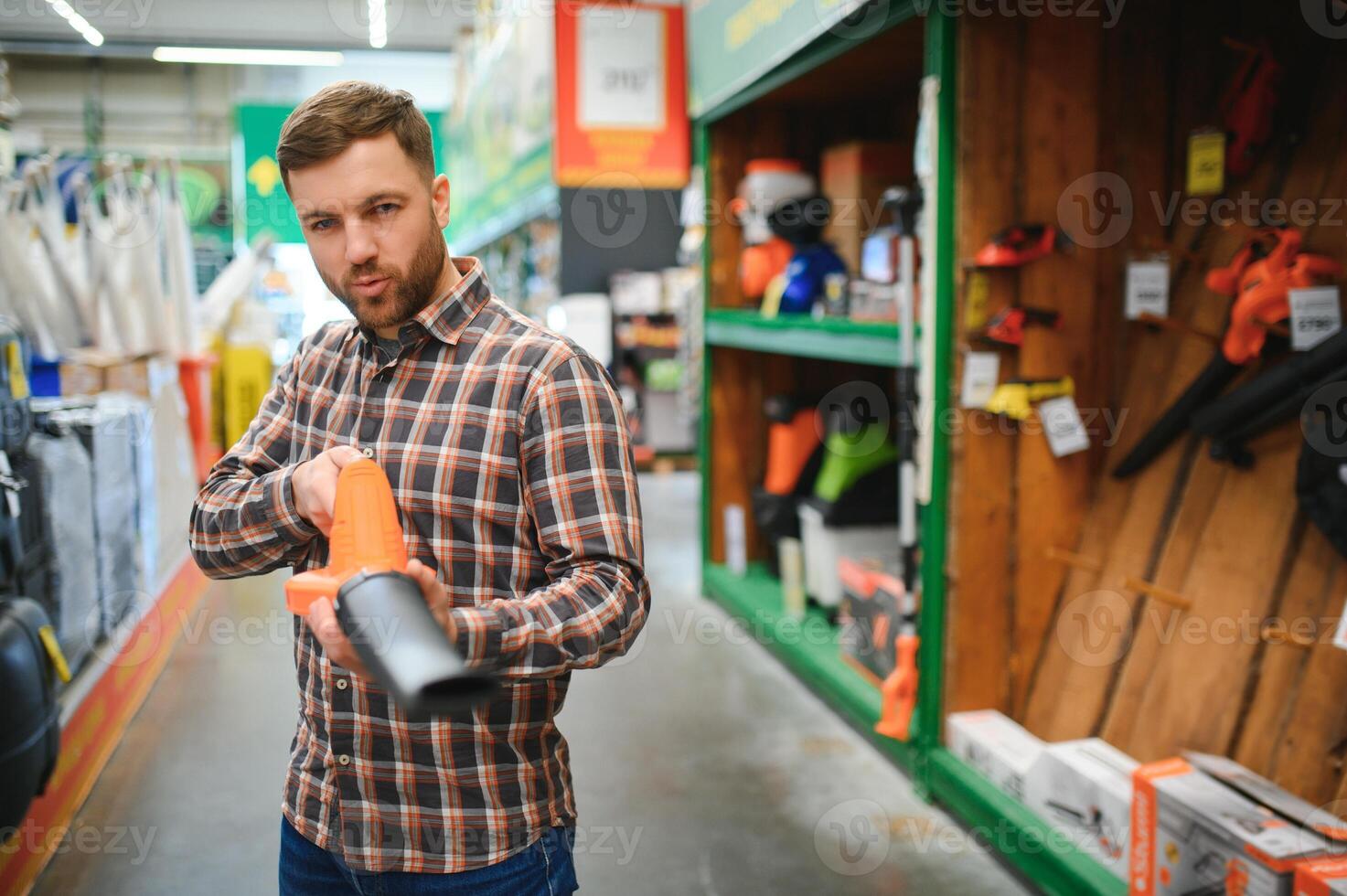 une Jeune homme dans une jardinage équipement boutique photo