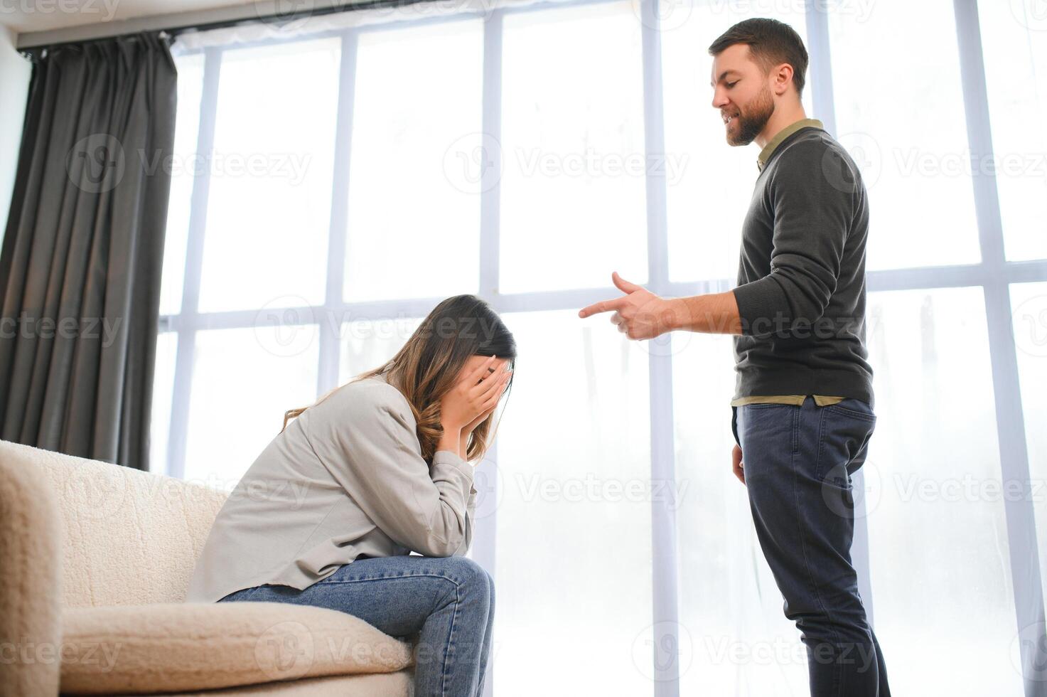 émotif homme faire des gestes et en criant à le sien épouse, Jeune couple ayant querelle à maison. national abuser de concept photo