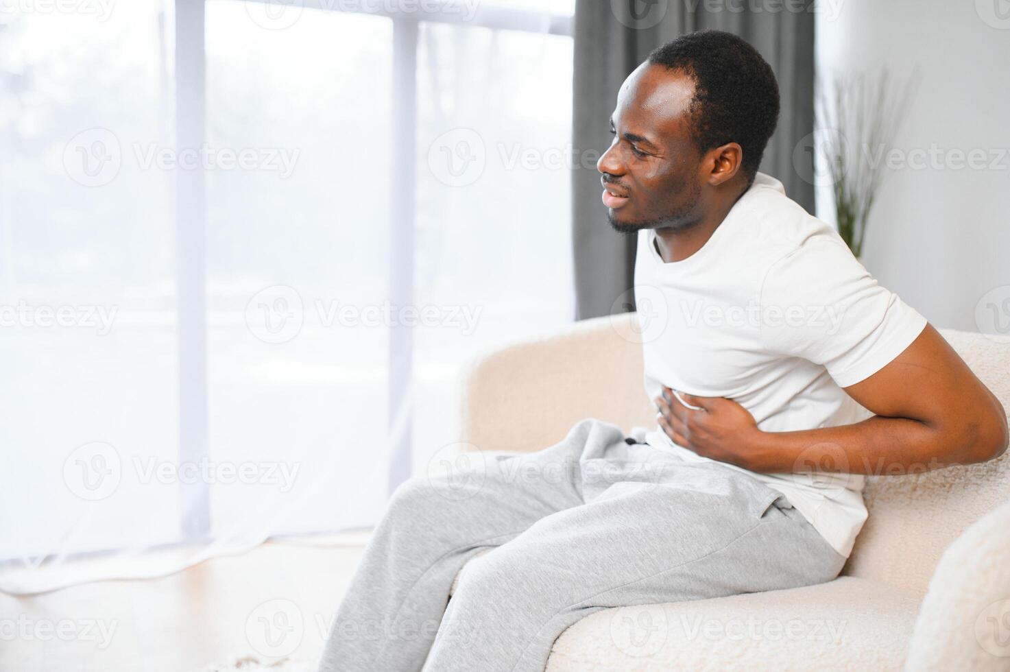 noir homme ayant maux d'estomac Souffrance de douloureux abdominal spasme permanent émouvant douloureux abdomen à Accueil photo