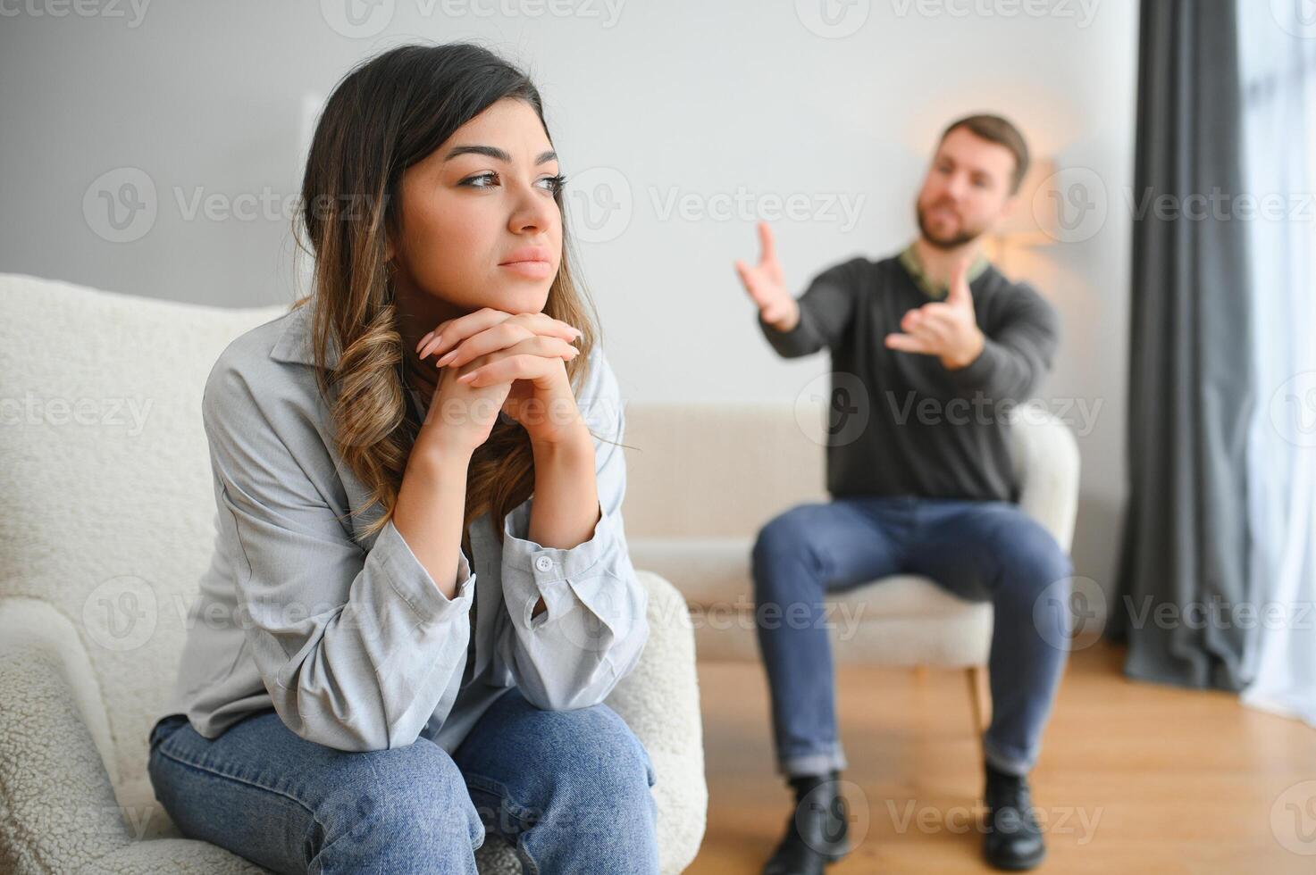 émotif homme faire des gestes et en criant à le sien épouse, Jeune couple ayant querelle à maison. national abuser de concept photo