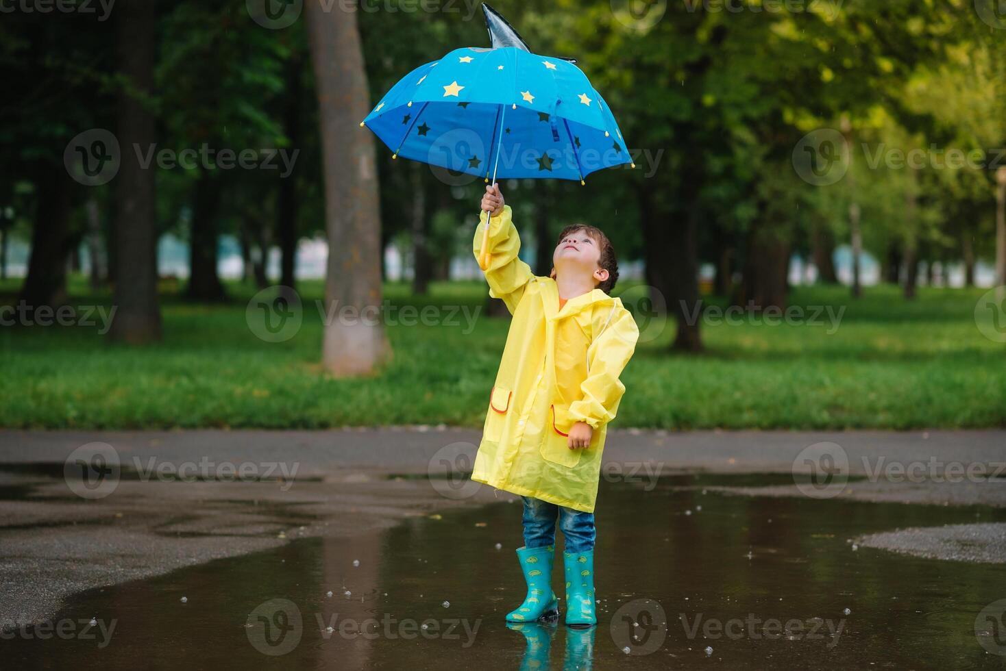 enfant en jouant avec jouet bateau dans flaque. enfant jouer Extérieur par pluie. tomber pluvieux temps en plein air activité pour Jeune les enfants. enfant sauter dans boueux flaques d'eau. imperméable veste et bottes pour bébé. enfance photo