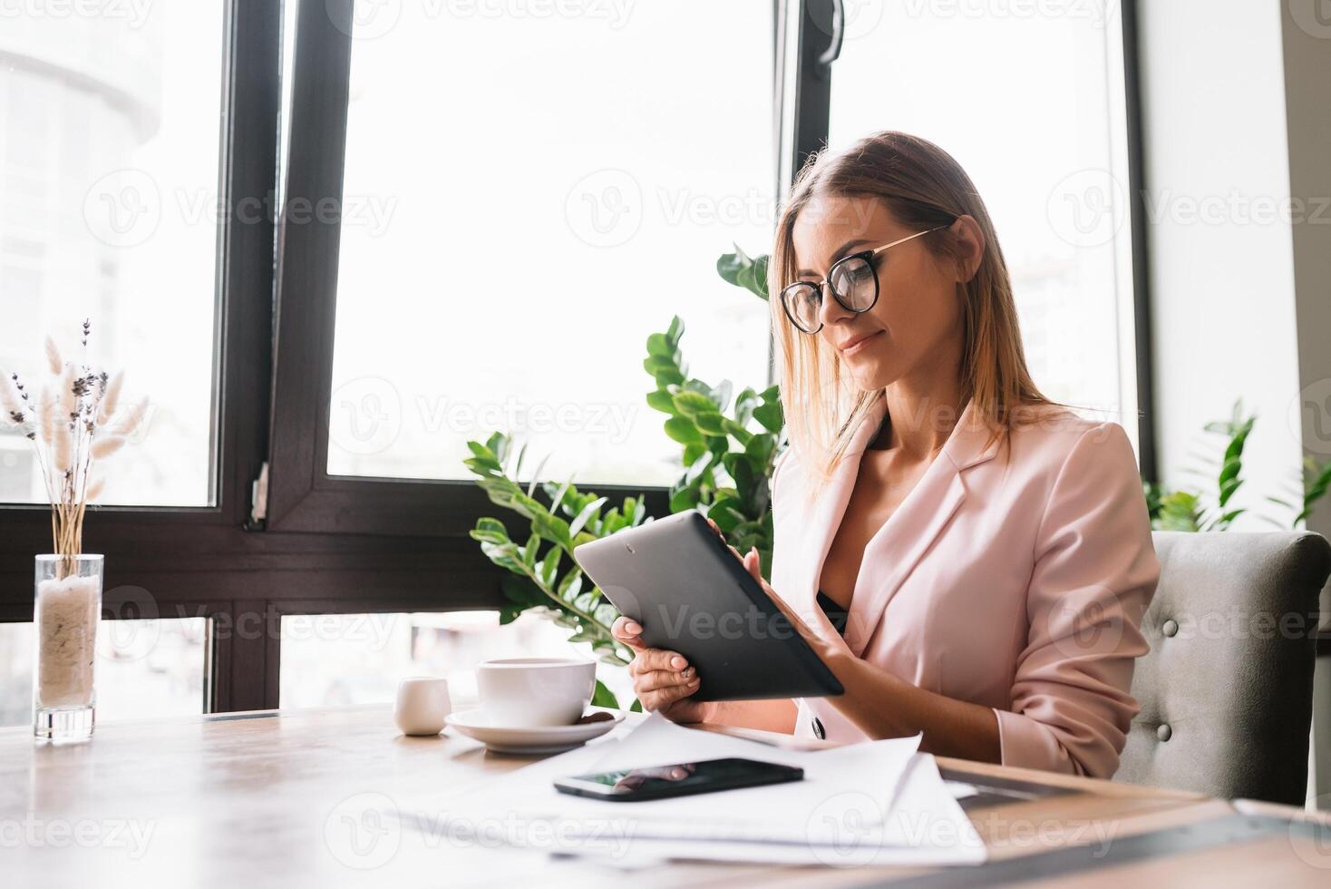 souriant femme d'affaires en utilisant tablette ordinateur café magasin. photo