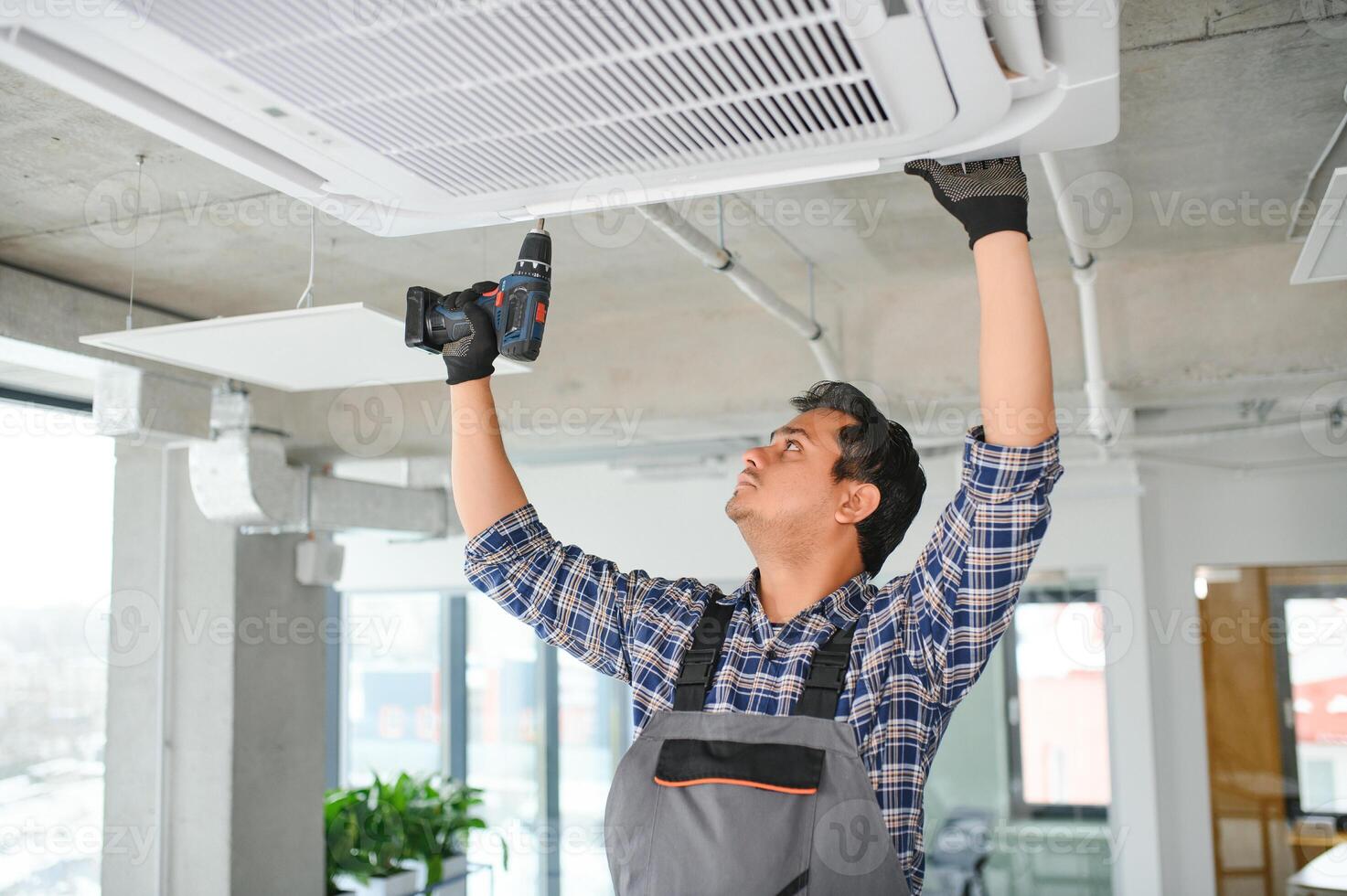 concentré Jeune Indien ingénieur réglage en haut air Conditionneur. photo