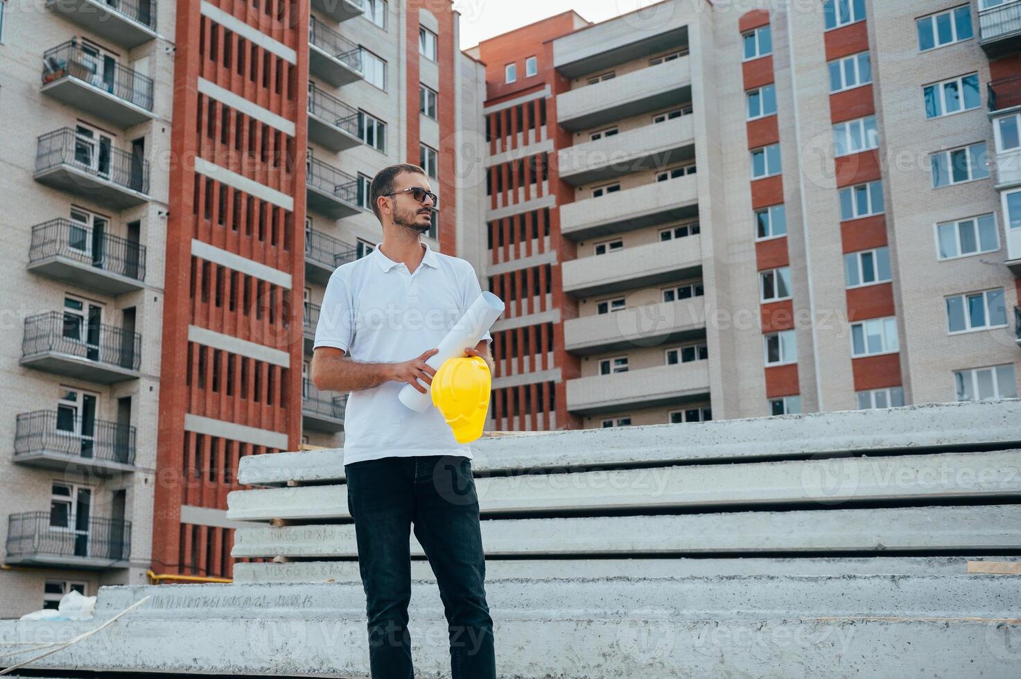 portrait de un architecte constructeur en train d'étudier disposition plan de le pièces, sérieux civil ingénieur travail avec les documents sur construction placer. photo