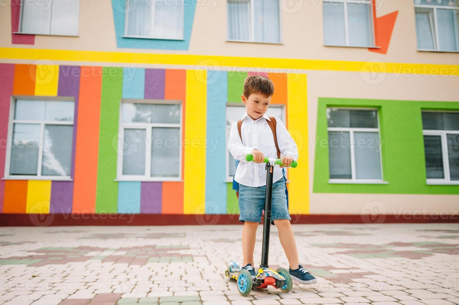 garçon va à école sur une scooter. les enfants retour à école scooter.childschool équitation une scooter. retour à école. content les enfants. content enfance mode de vie. étudiant va à école photo