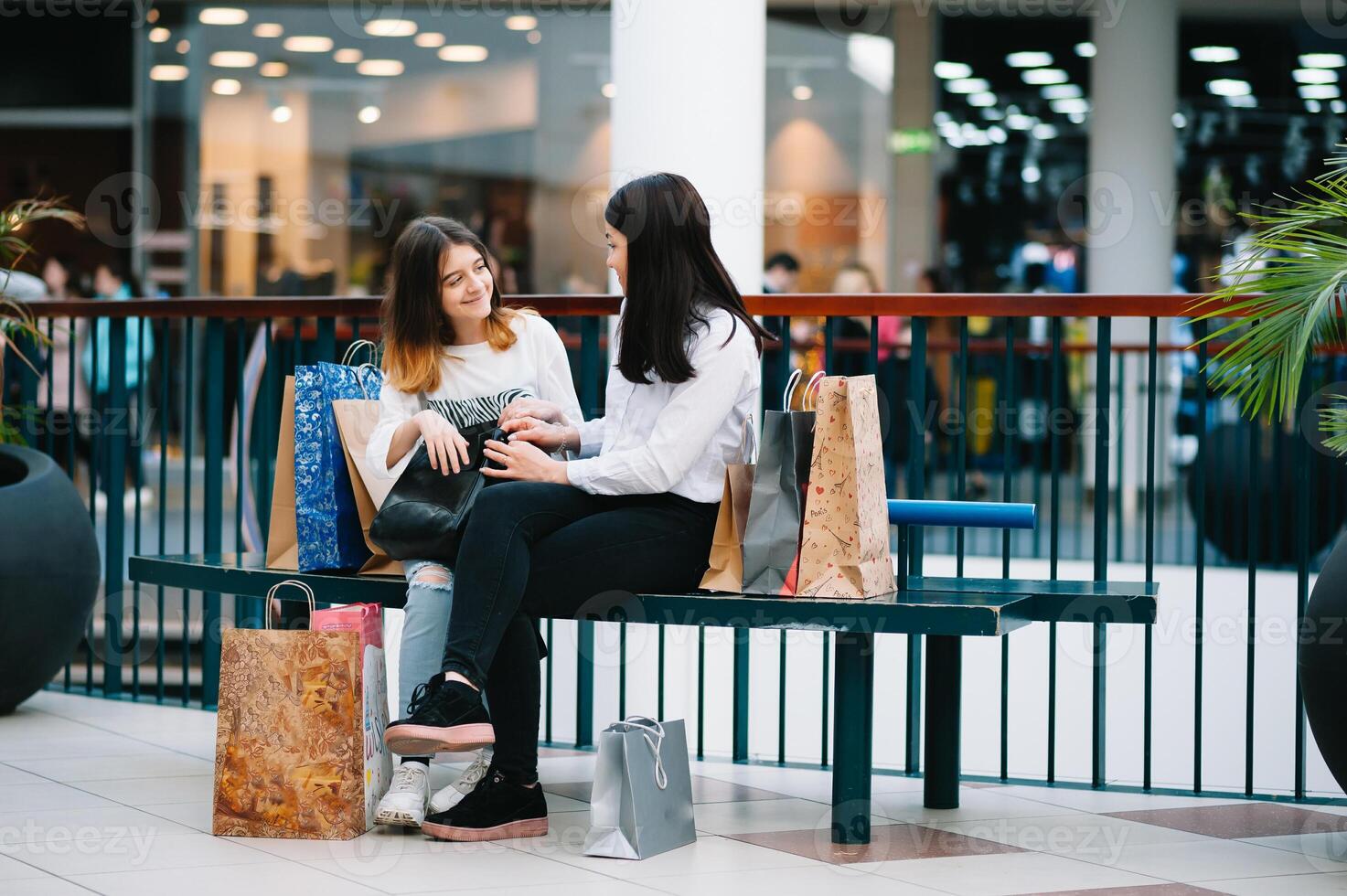 magnifique Jeune maman et adolescent fille sont en portant achats Sacs, achats dans centre commercial. famille achats photo