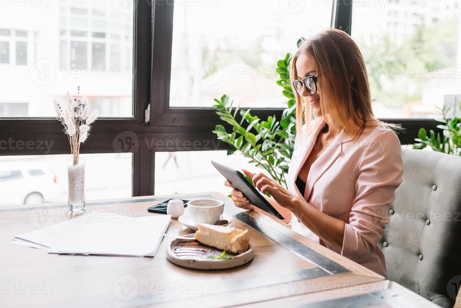 souriant femme d'affaires en utilisant tablette ordinateur café magasin. photo