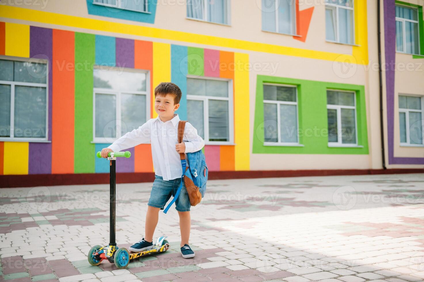 garçon va à école sur une scooter. les enfants retour à école scooter.childschool équitation une scooter. retour à école. content les enfants. content enfance mode de vie. étudiant va à école photo