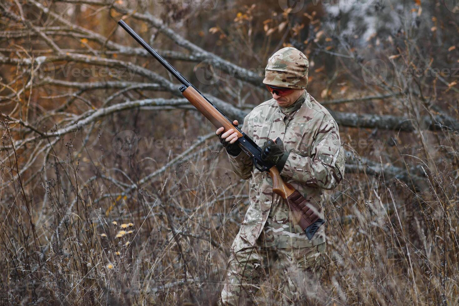 chasseur Beau gars avec arme. chasseur dépenser loisir chasse. chasse équipement. brutal masculin passe-temps. homme observer la nature Contexte. chasseur tenir fusil. sécurité mesures. Naturel environnement photo